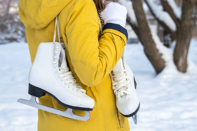 Close up of female hands holding ice skates.