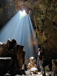 People standing by rocks at waterfall