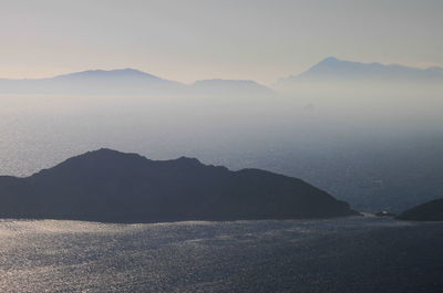 Scenic view of sea and mountains against sky