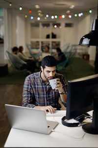 Businessman having coffee while working late in creative office