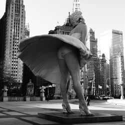 Midsection of man with skyscrapers against sky in city