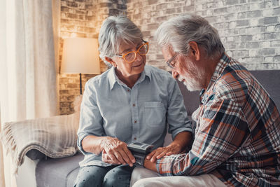 Side view of senior couple sitting on sofa at home