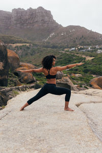 Side view of woman sitting on rock