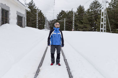 Man standing on snow covered trees during winter