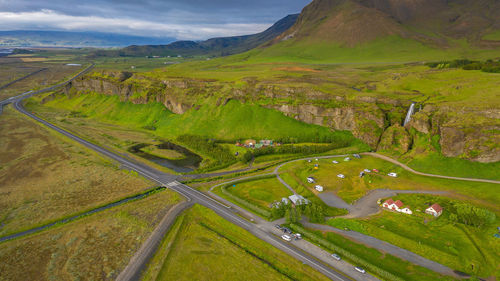 High angle view of road amidst field against sky