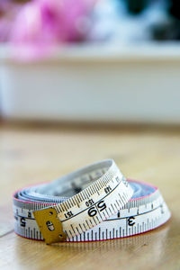 Close-up of tape measure on wooden table