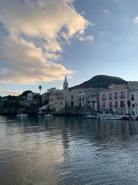 Buildings by town against sky during sunset