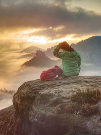 Woman just enjoying the life. beautiful girl backpacker sitting on top of the mountain and enjoy day