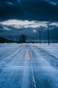 Snowy road against sky during winter