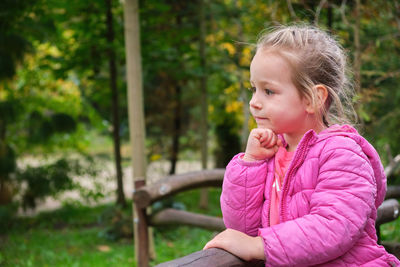 Side view of young woman sitting outdoors