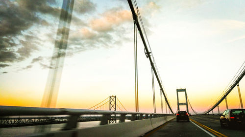 Low angle view of suspension bridge against sky during sunset