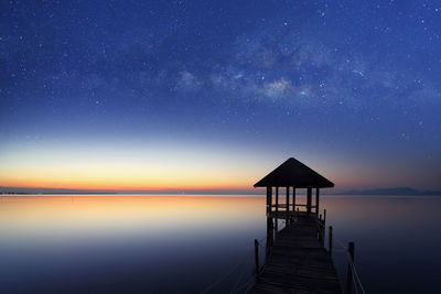 Pier over sea against sky at night