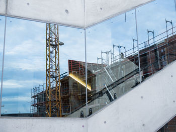 Low angle view of crane at construction site against sky