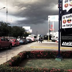 Cars on city street against sky