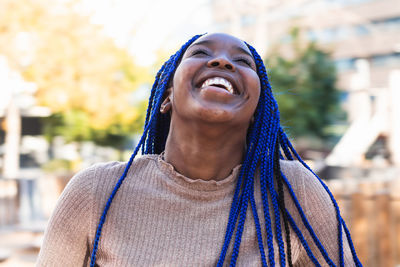 Portrait of smiling young woman looking away outdoors