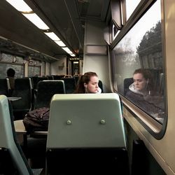 Rear view of woman sitting in train