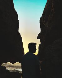 Rear view of man standing on rock formations