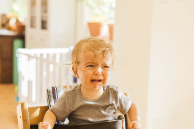 Boy in high chair crying at home