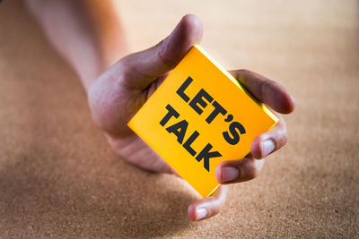 Close-up of hand holding yellow text