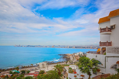 Scenic view of beach by city against sky