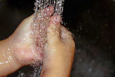 Cropped image of child washing hands