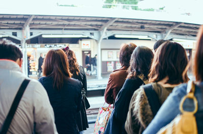 Rear view of people traveling in city