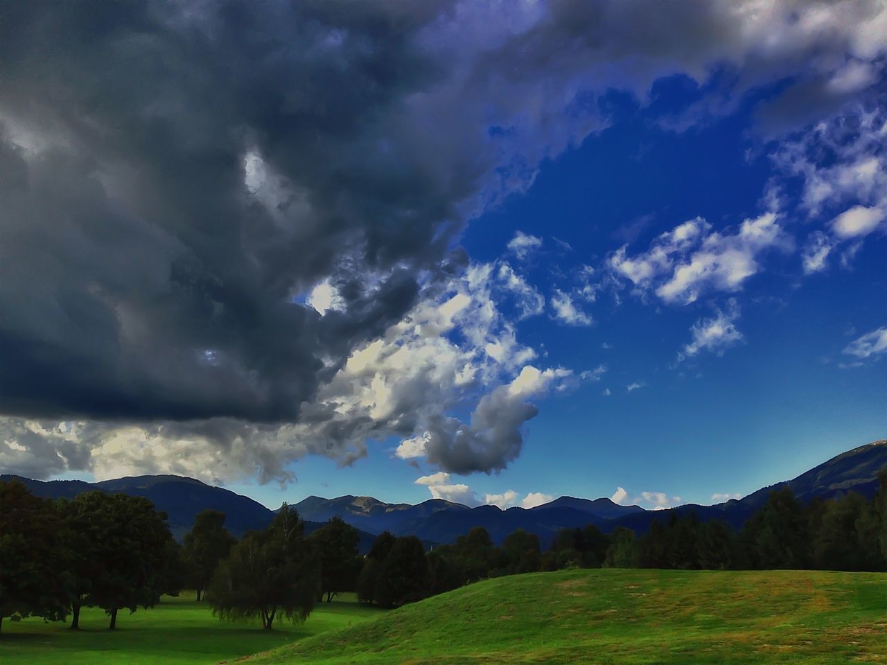 sky, landscape, tranquil scene, scenics, mountain, tranquility, beauty in nature, cloud - sky, nature, cloudy, grass, mountain range, cloud, field, tree, non-urban scene, green color, idyllic, remote, countryside