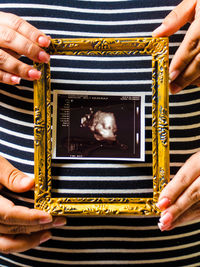 Close-up of woman photographing against gray background