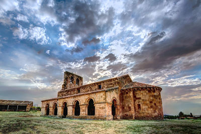 Low angle view of old building against cloudy sky
