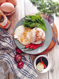 High angle view of food in plate on cutting board over table