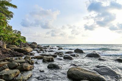 Rocks on beach against sky