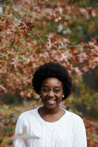 Portrait of smiling woman standing outdoors during autumn