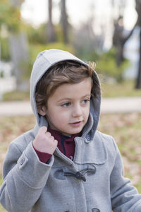 Boy looking away while standing outdoors