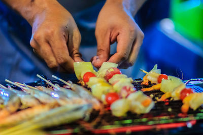 Close-up of man working on barbecue grill