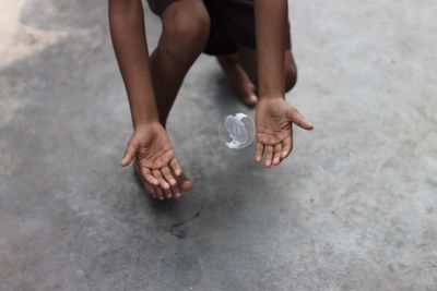 Midsection of boy catching bubble on street