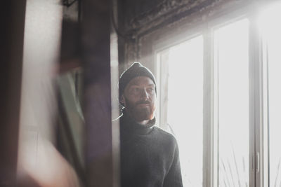 Portrait of man looking through window