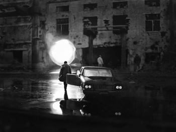 Rear view of a man standing on street at night
