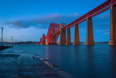 Golden gate bridge over river against cloudy sky