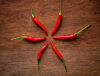 High angle view of red chili peppers on wood