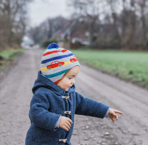 Rear view of boy looking at park during winter