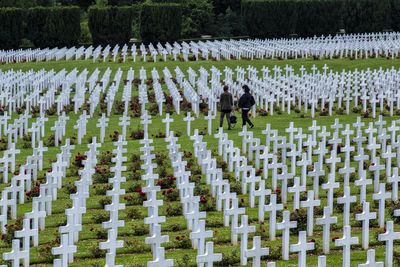 People amidst cross in cemetery