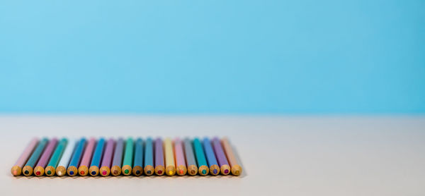 Close-up of colored pencils against blue background