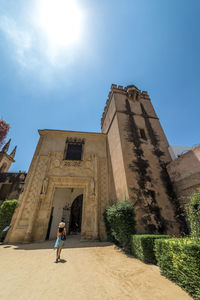 Low angle view of woman walking against building