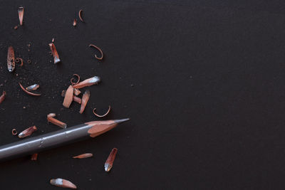 Pencil with shavings on black background