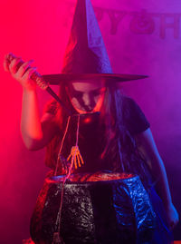 Midsection of woman standing against illuminated wall during halloween