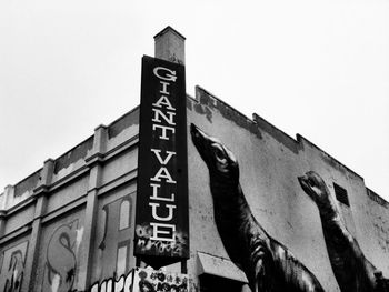 Low angle view of text on building against clear sky