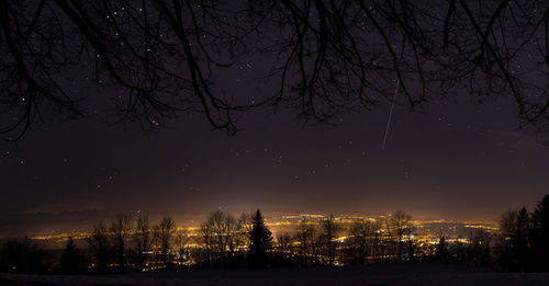 Illuminated city against sky at night