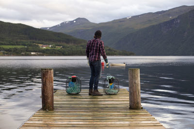 A fisherman surveying the scene across the fjord