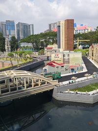 Bridge over river amidst buildings in city against sky