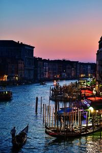 Boats in river against sky during sunset